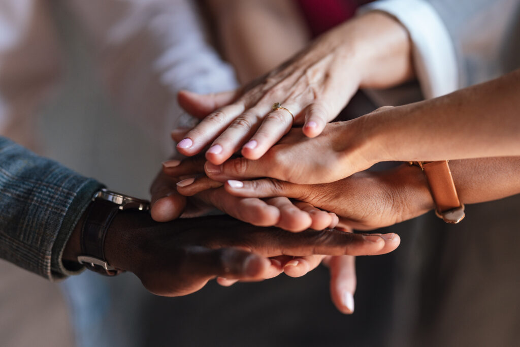 A close-up image of diverse hands stacked together, symbolizing collaboration for the Thrive Plus fixed indexed annuity product launch of The Standard and Ignite Partners.